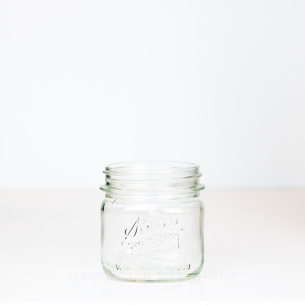 Kerr wide mouth pint mason jar with &quot;self-sealing&quot; logo, against a white background