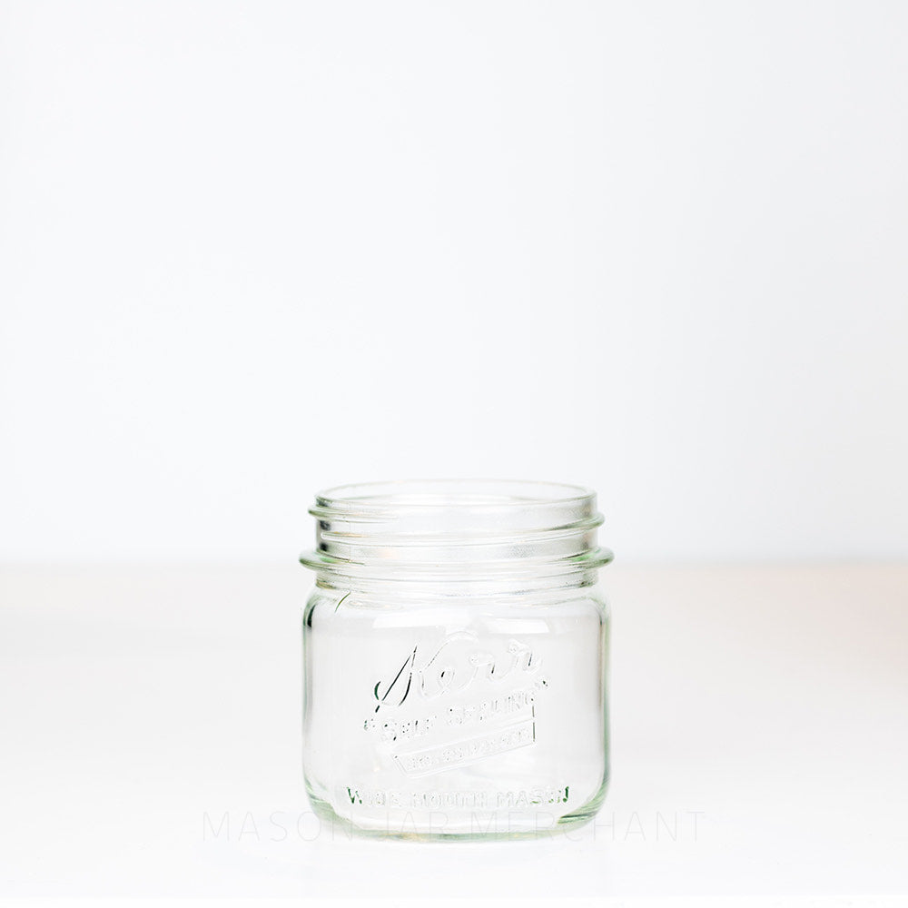 Kerr wide mouth pint mason jar with &quot;self-sealing&quot; logo, against a white background 