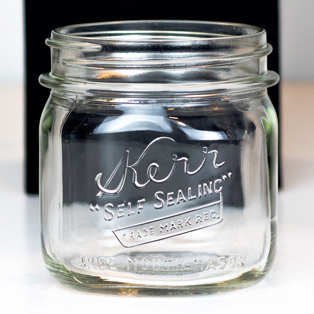 close up of a Vintage Kerr Self Sealing Short Square Wide Mouth Pint Mason Jar on a white background.