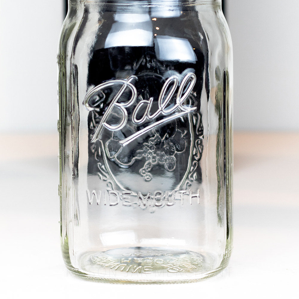 Close up of a Wide mouth quart mason jar with Ball logo, against a white background