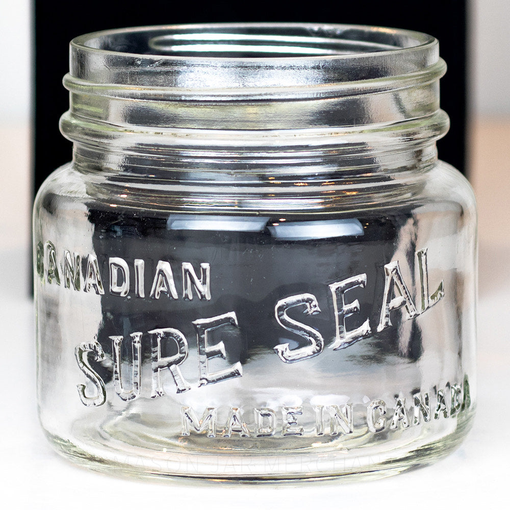 A close up of a Vintage wide mouth pint mason jar with Canadian Sure Seal logo, against a white background