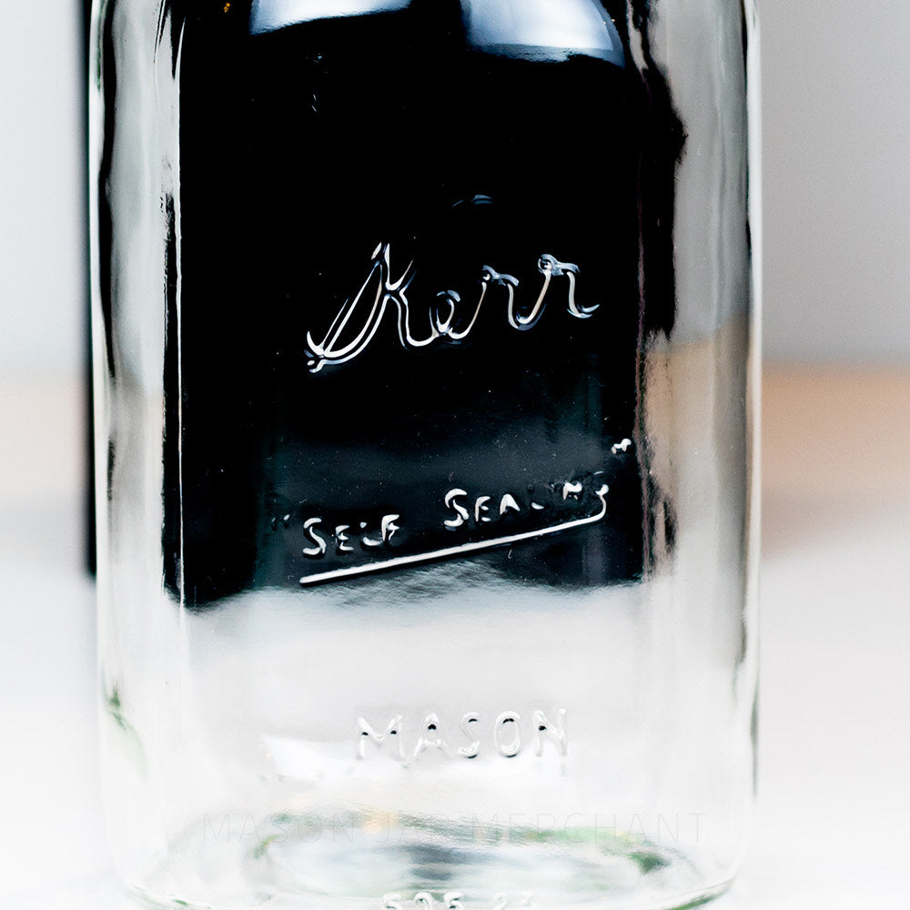 A close up of a Regular mouth quart mason jar with Kerr self-sealing logo against a white background