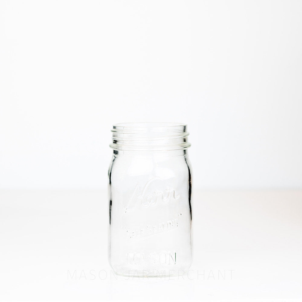 Kerr regular mouth pint mason jar with Self-sealing logo against a white background 