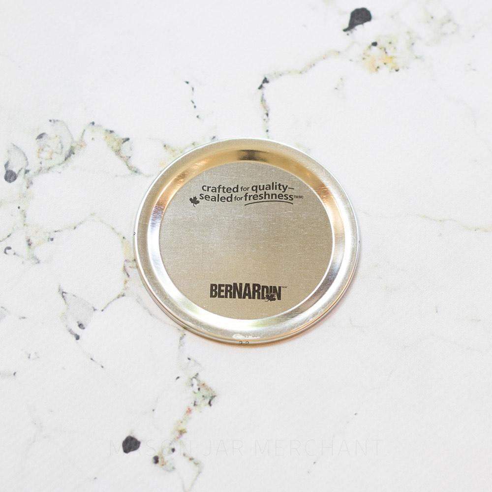 close up of a regular mouth Bernardin canning lid on a marble white background 