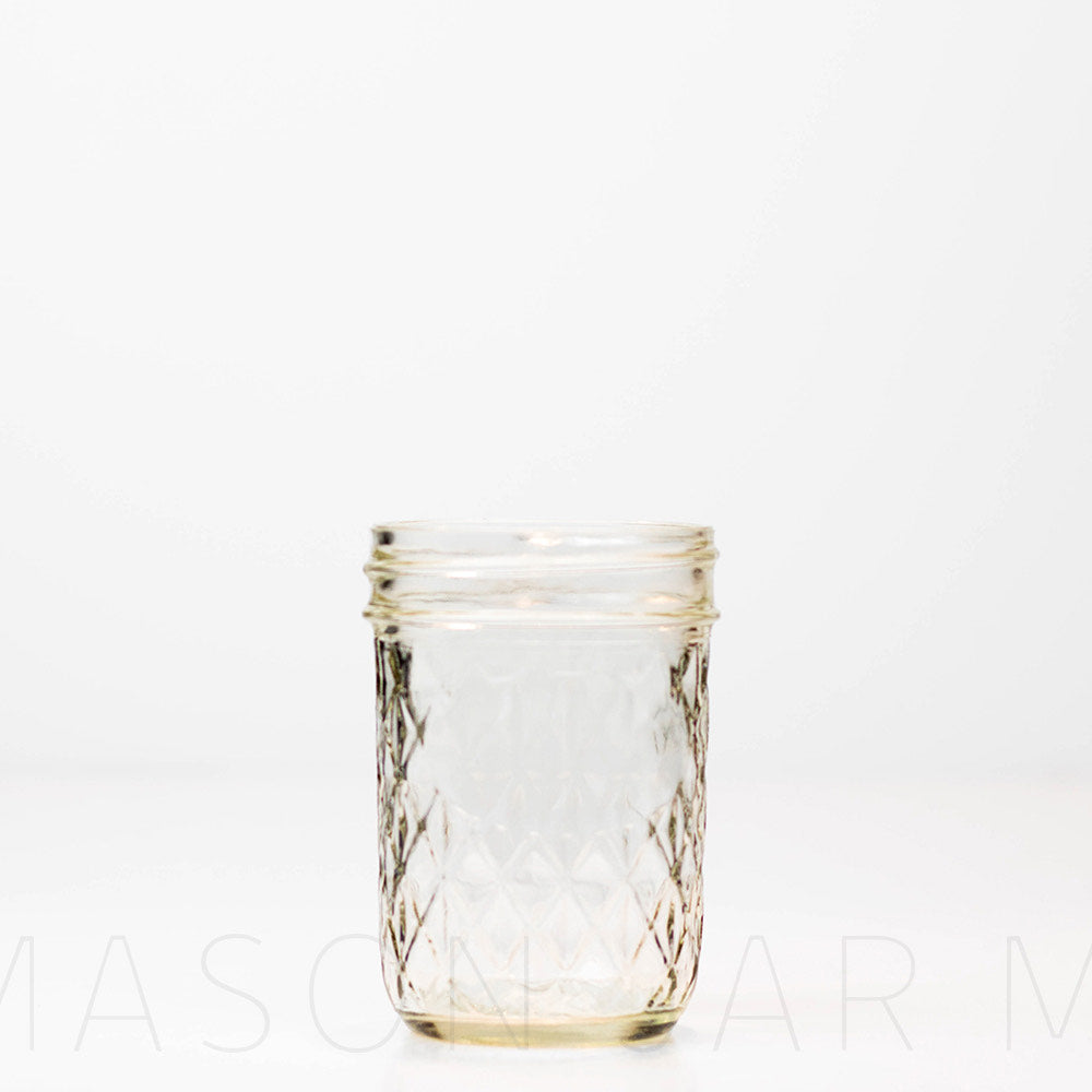 Regular mouth half pint mason jar with a quilted pattern, against a white background