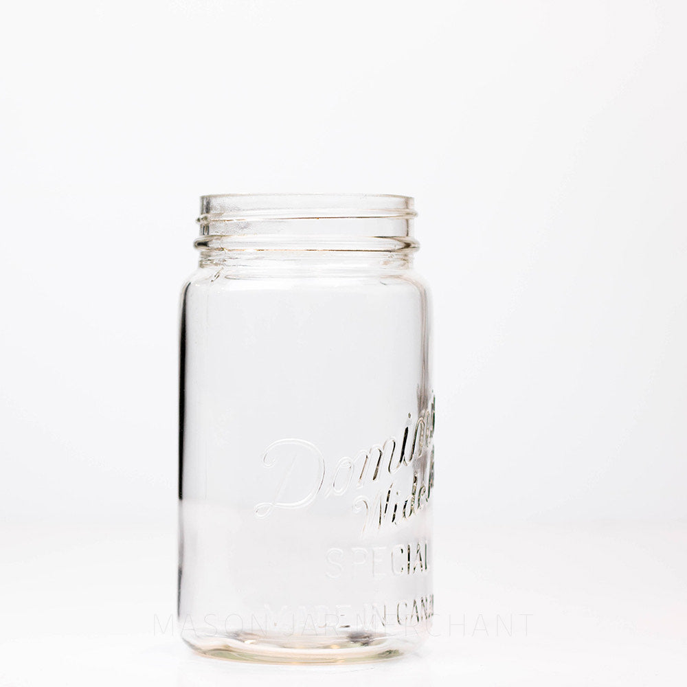 A side view of a Vintage wide mouth Dominion mason jar quart against a white background