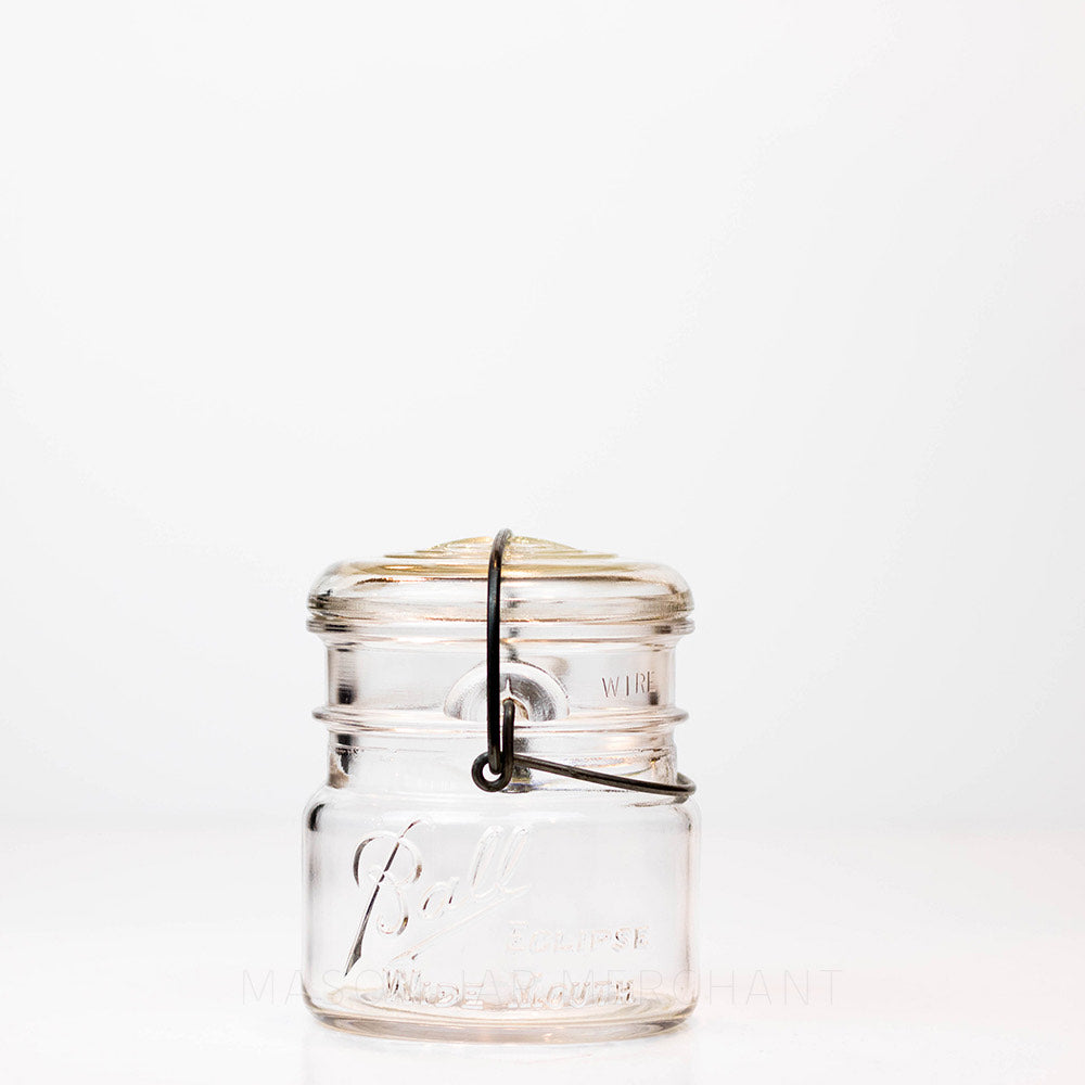 Vintage wide mouth wire bail Ball mason jar against a white background