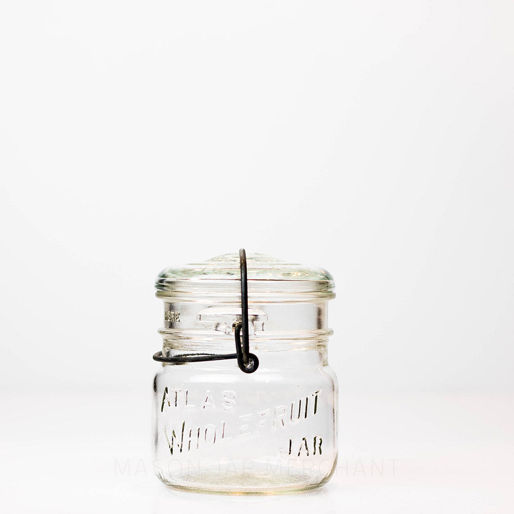 Vintage 1940s Atlas Wholefruit wide mouth wire bail mason jar against a white background