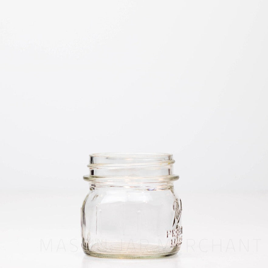 Close-up of a cute sub 8 oz regular mouth mason jar with Ball Perfect Mason logo, against a white background