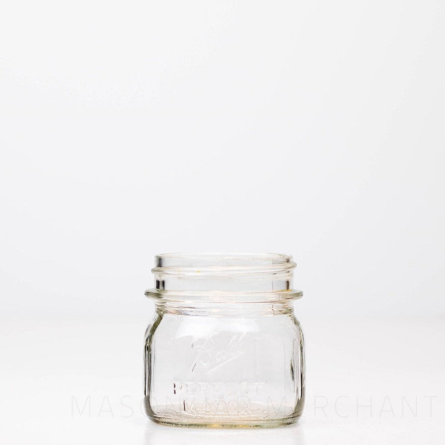 Close-up of a cute sub 8 oz regular mouth mason jar with Ball Perfect Mason logo, against a white background