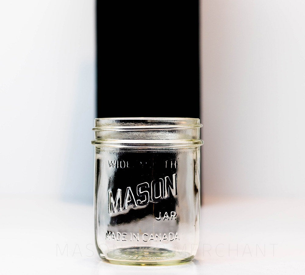 close up of a Mason brand wide mouth pint mason jar with logo showing, on a white background