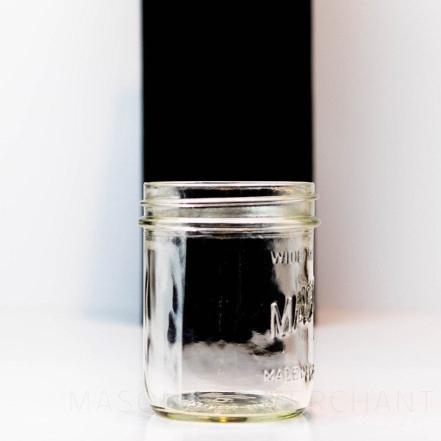 side view of a Mason brand wide mouth pint mason jar with logo showing, on a white background
