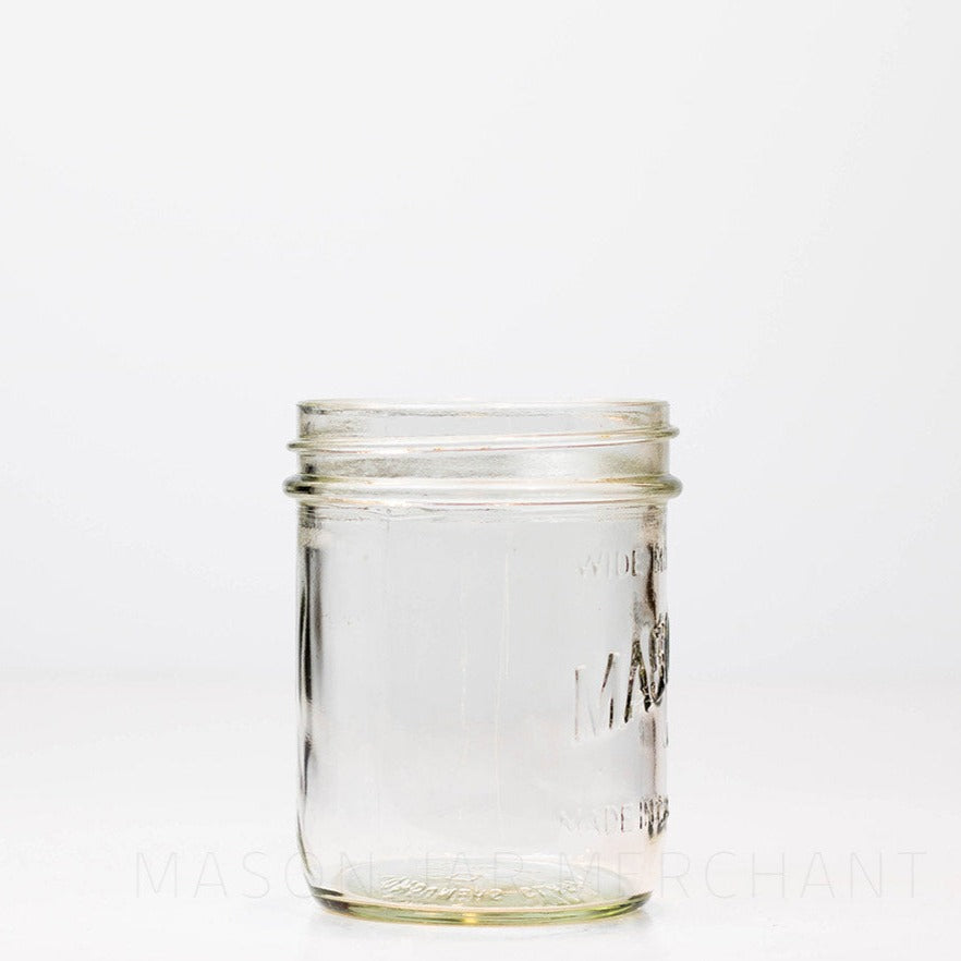 Side view of a Mason brand wide mouth pint mason jar with logo showing, on a white background
