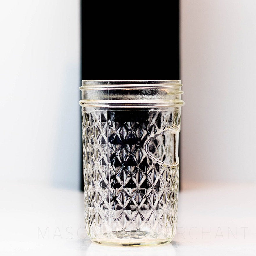 Side view of a quilted wide mouth glass mason jar on a black and white background