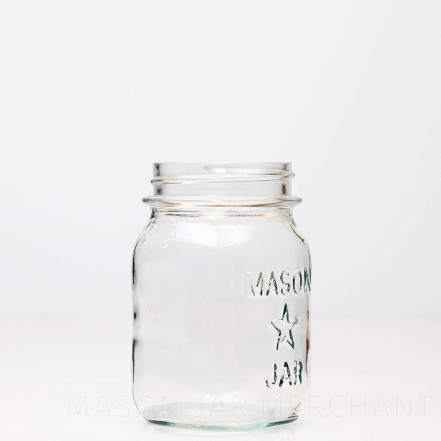Regular mouth pint mason jar with mason star logo on a white background