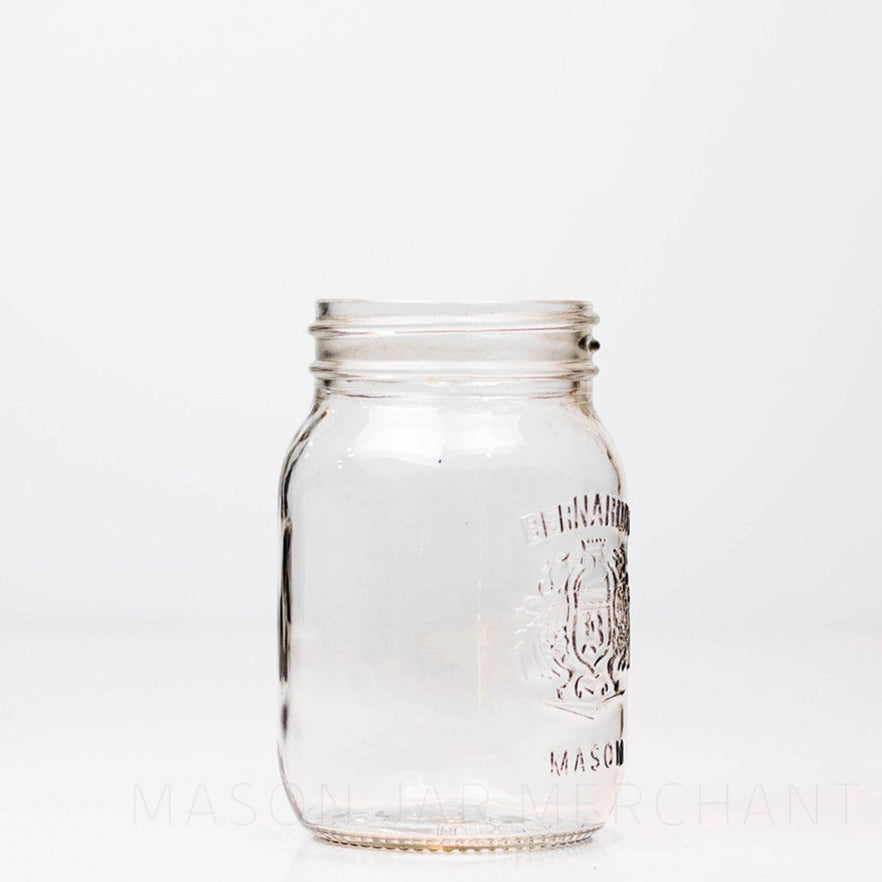 Side view of a Regular mouth pint mason jar with a Bernardin crest logo on the front, against a white background