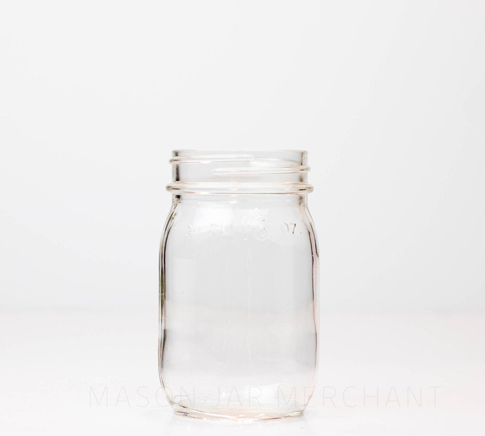 Vintage regular mouth pint mason jar with FL 16 oz imprinted near the rim, against a white background