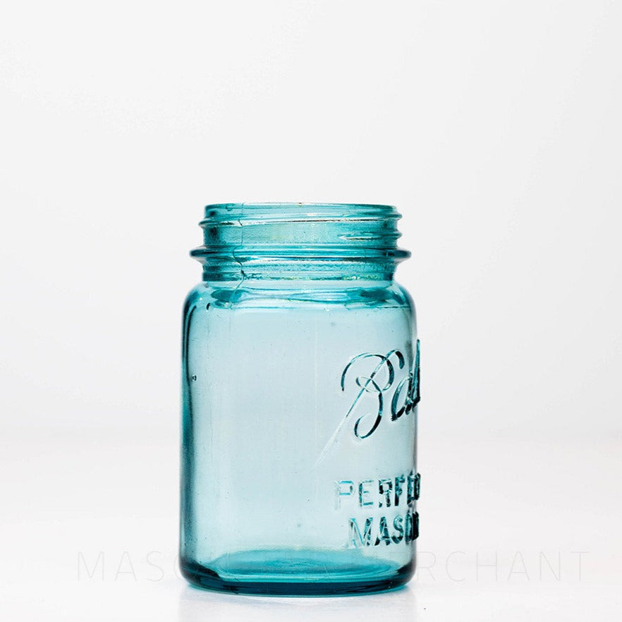 Side view of a Vintage blue regular mouth Ball pint size mason jar against a white background