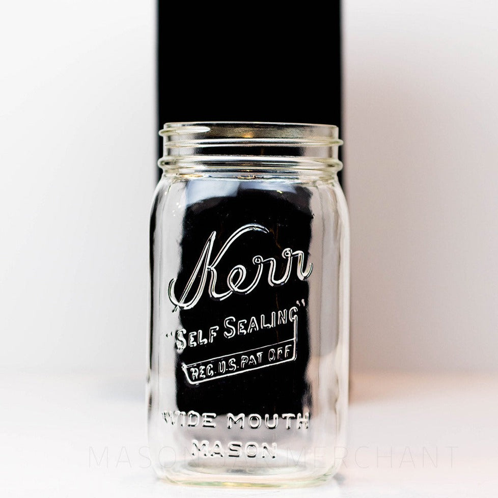 A close up of a Wide mouth quart mason jar with Kerr self-sealing logo against a white background