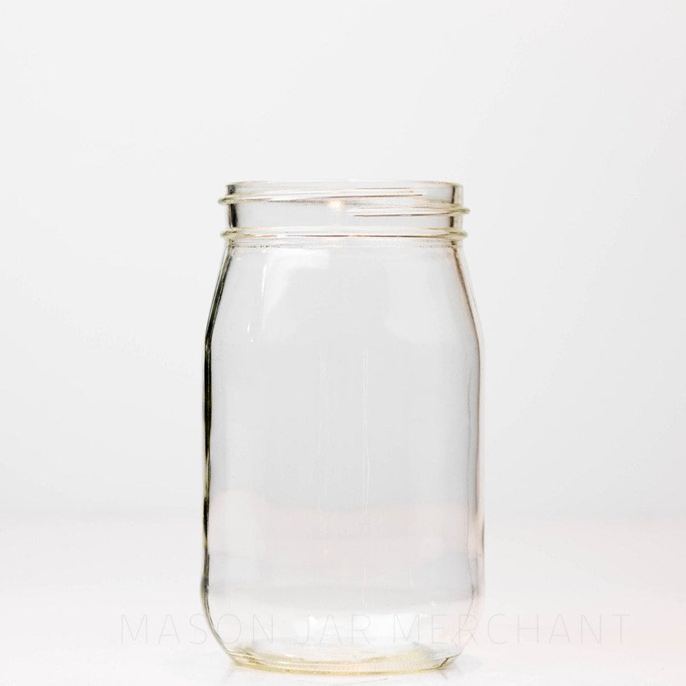 Regular mouth pint mason jar with soft "shoulders" and no logo, against a white background