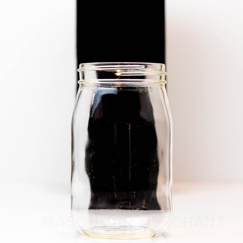 Regular mouth pint mason jar with soft "shoulders" and no logo, against a white background