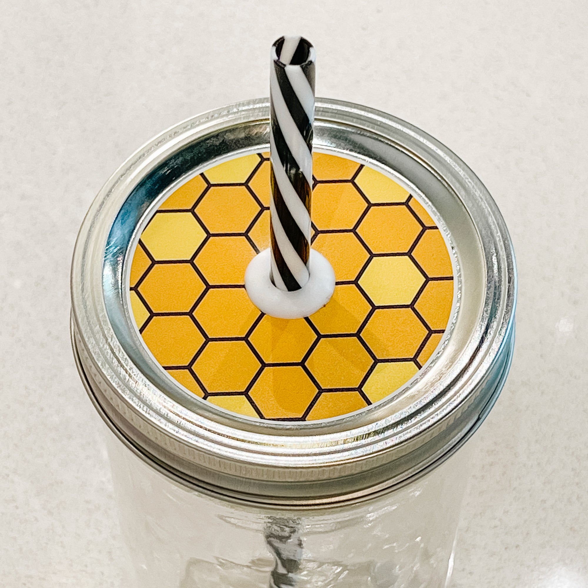 top photo of mason jar lid with honeycomb design and a black outline