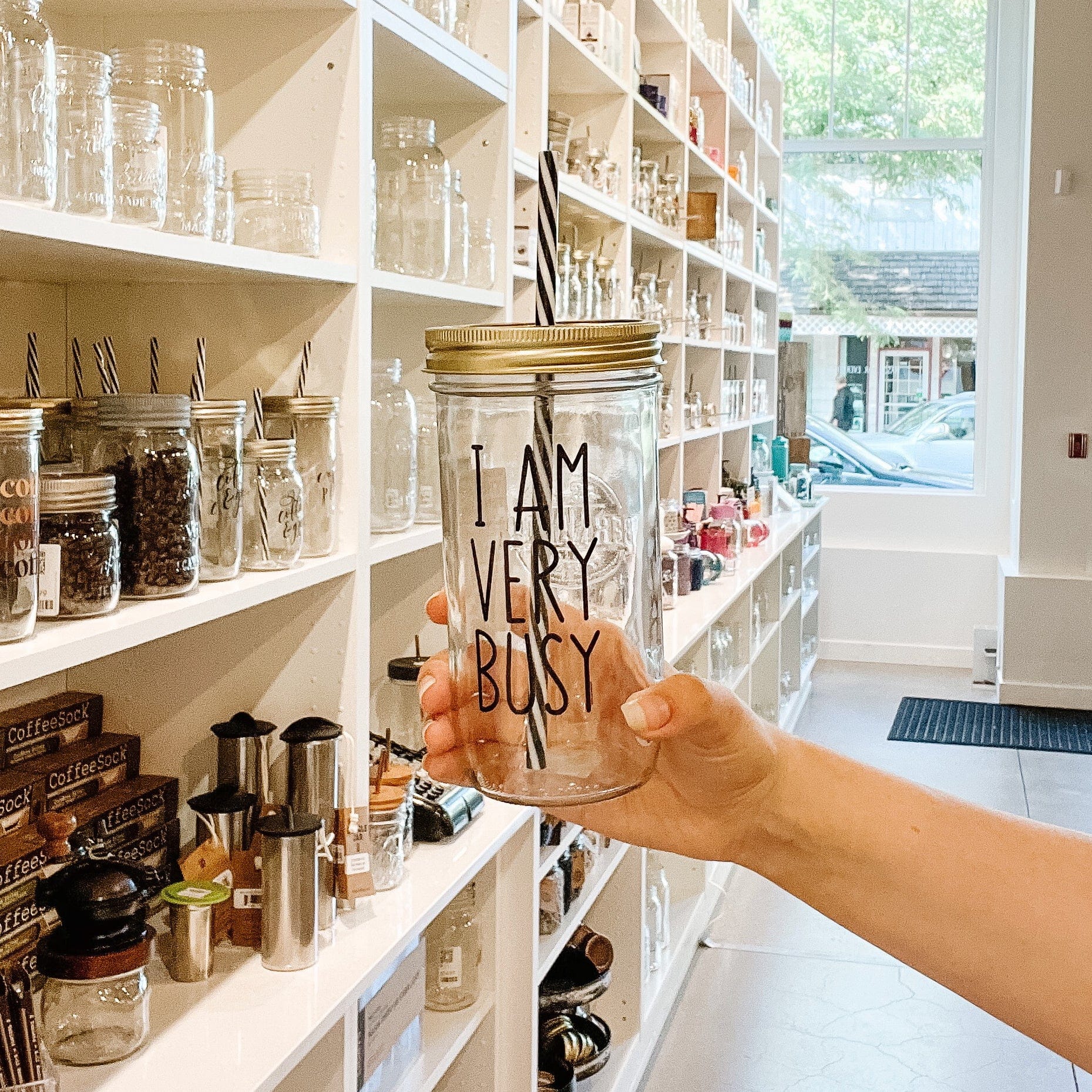 Photo of a mason jar tumblr with a 'I am very busy' sticker on it