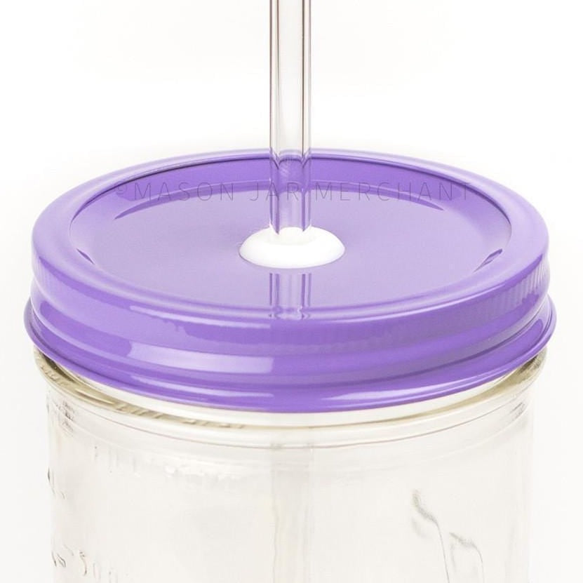 Close-up of a 24 oz mason jar with a purple custom painted lid with a white silicone grommet and a glass straw, against a white background