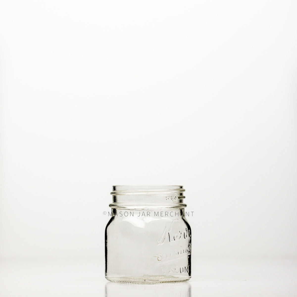 Regular mouth half-pint mason jar with square sides and Kerr self-sealing logo against a white background