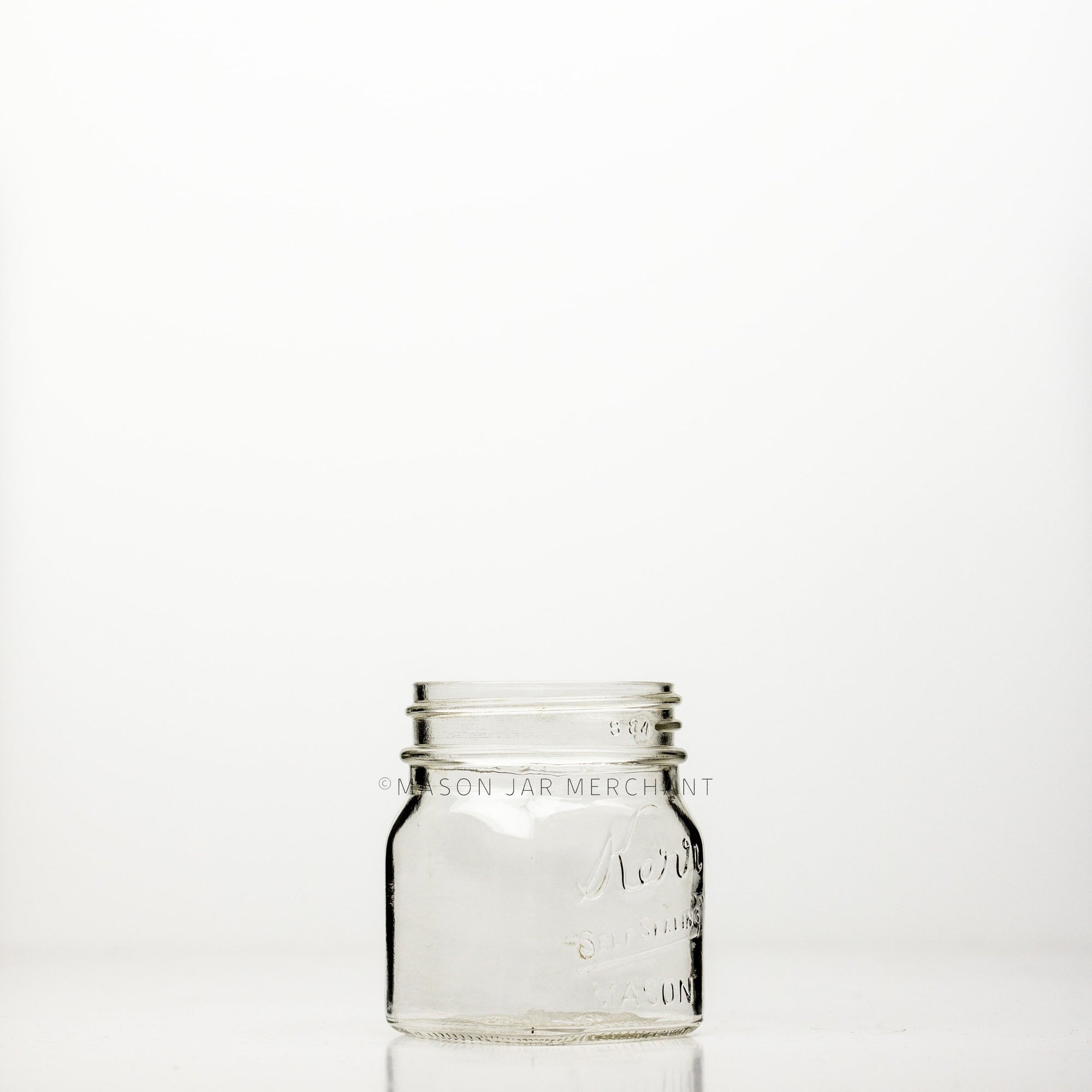 Regular mouth half-pint mason jar with square sides and Kerr self-sealing logo 