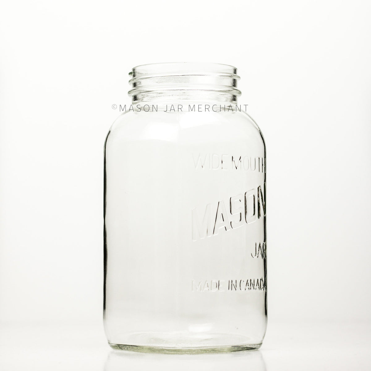 A side view of a Wide mouth half-gallon mason jar with Mason logo, against a white background