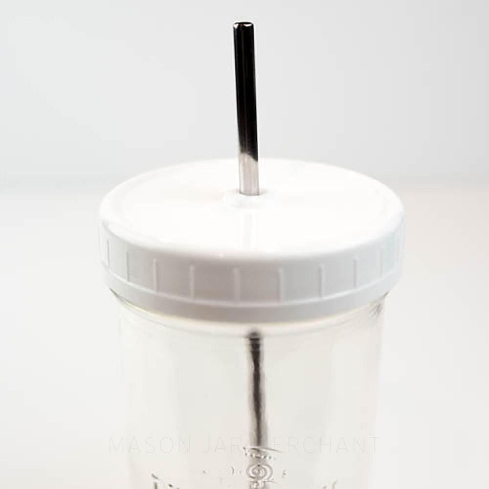 White wide mouth mason jar straw lid on a mason jar, with a stainless steel straw