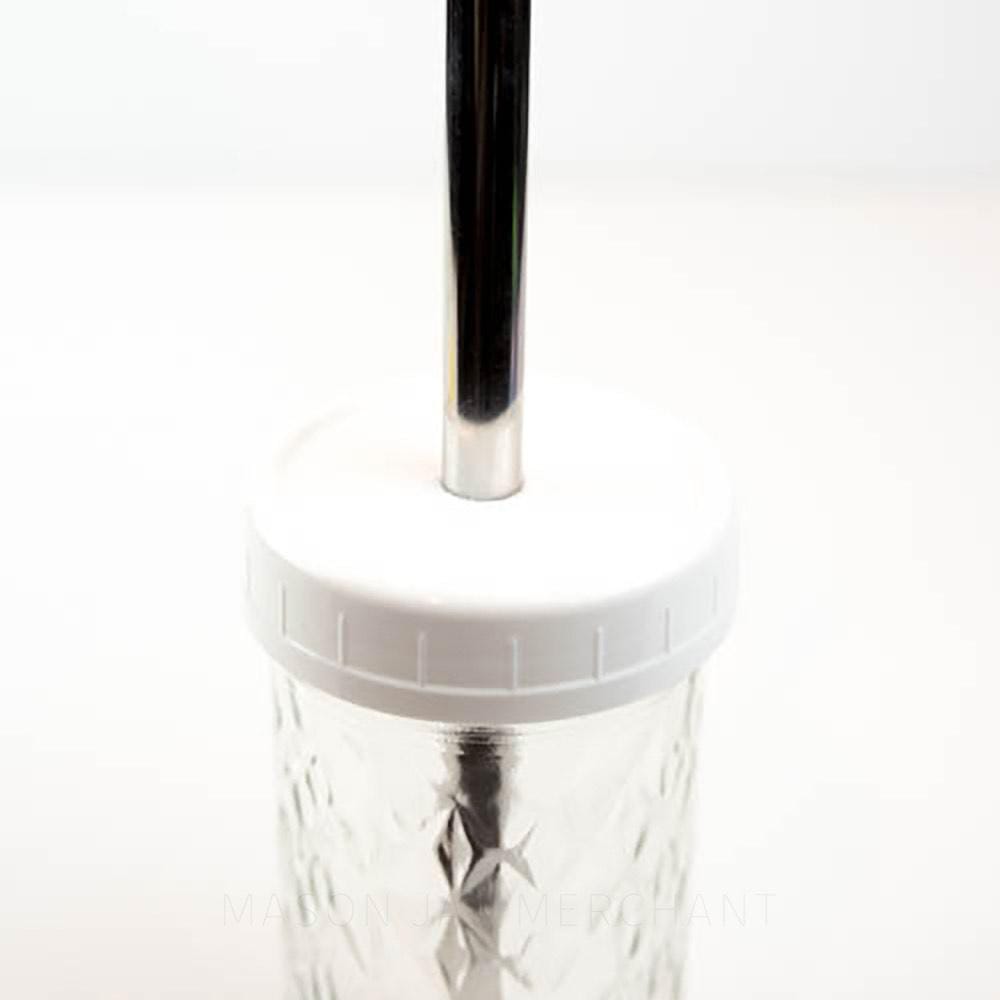 White regular mouth mason jar straw lid on a mason jar, with a stainless steel bubble tea straw