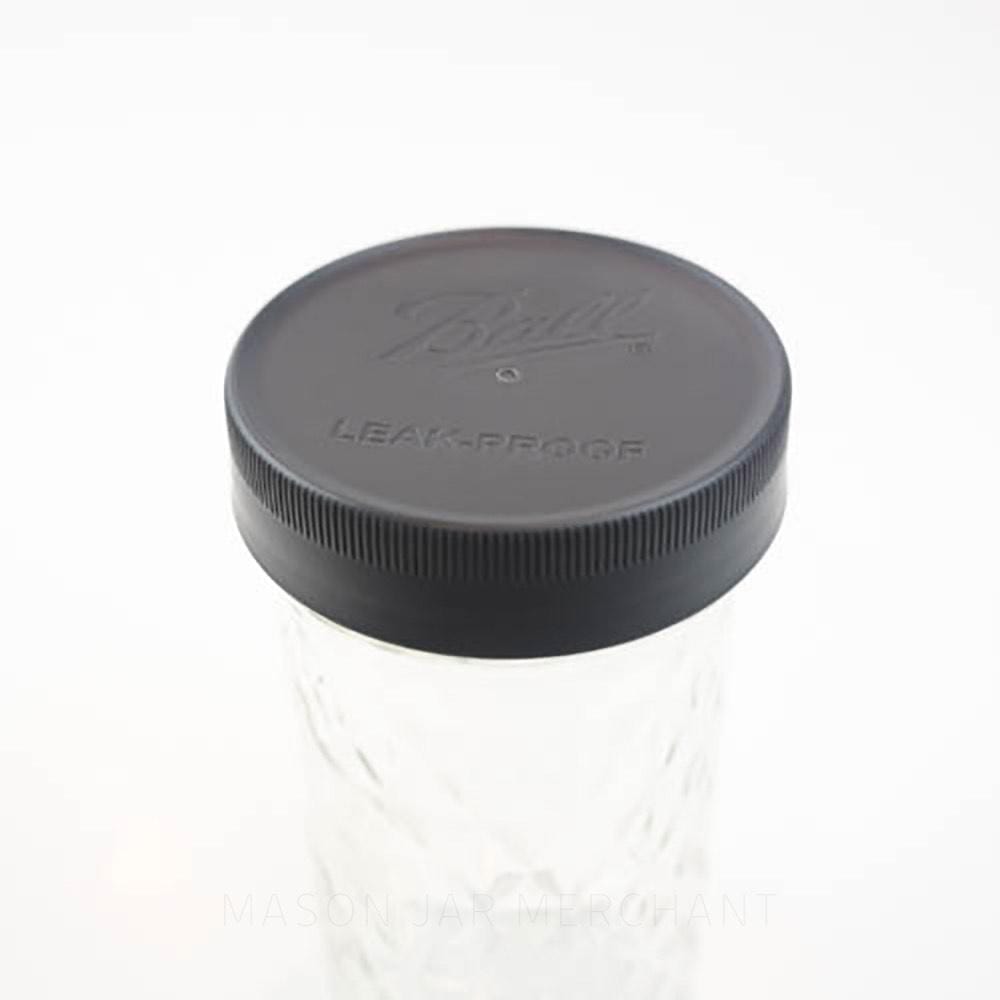 Close-up of a Ball brand regular mouth mason jar storage lid on a mason jar against a white background