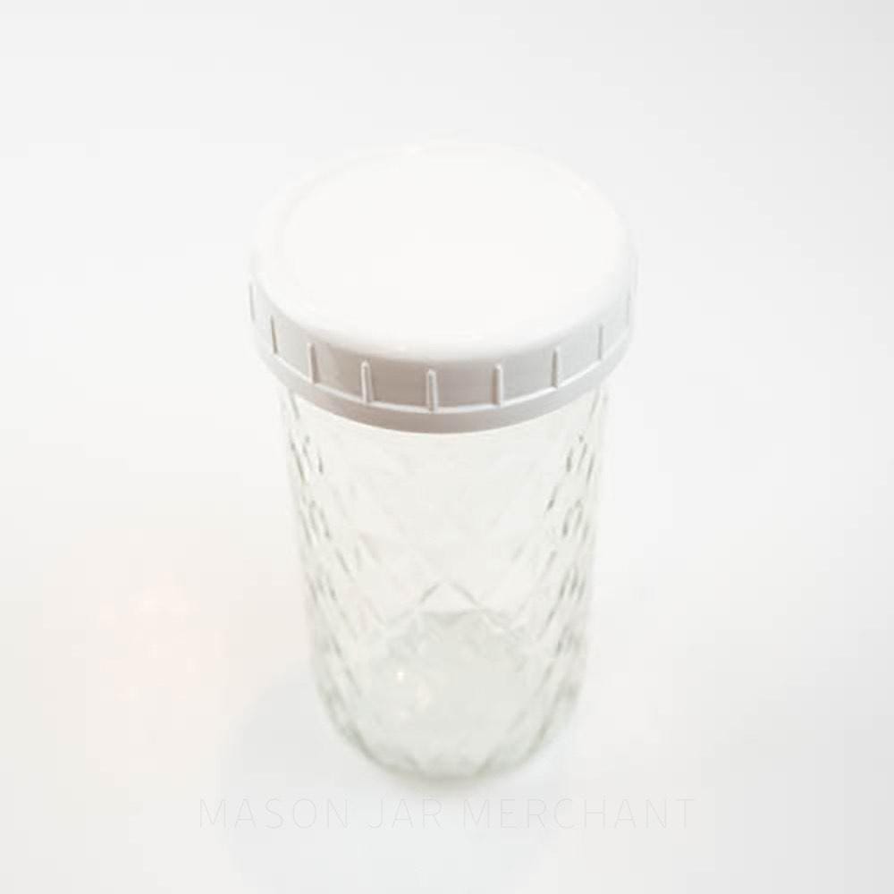 White plastic storage lid on a wide mouth mason jar against a white background
