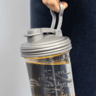 Four different sizes and kinds of glass reusable mason jars with reCAP easy pour spout wide mouth mason jar lids. In the colours grey, black, teal and white on a white background