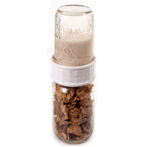 a to go jar with a spill proof white wide mouth lid. In the bottom jar is some cereal and the top jar is filled with milk. The jars sit on a white background