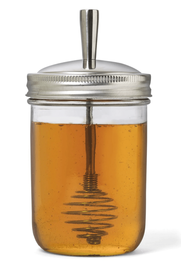 Photo of a jar with a honey dipper