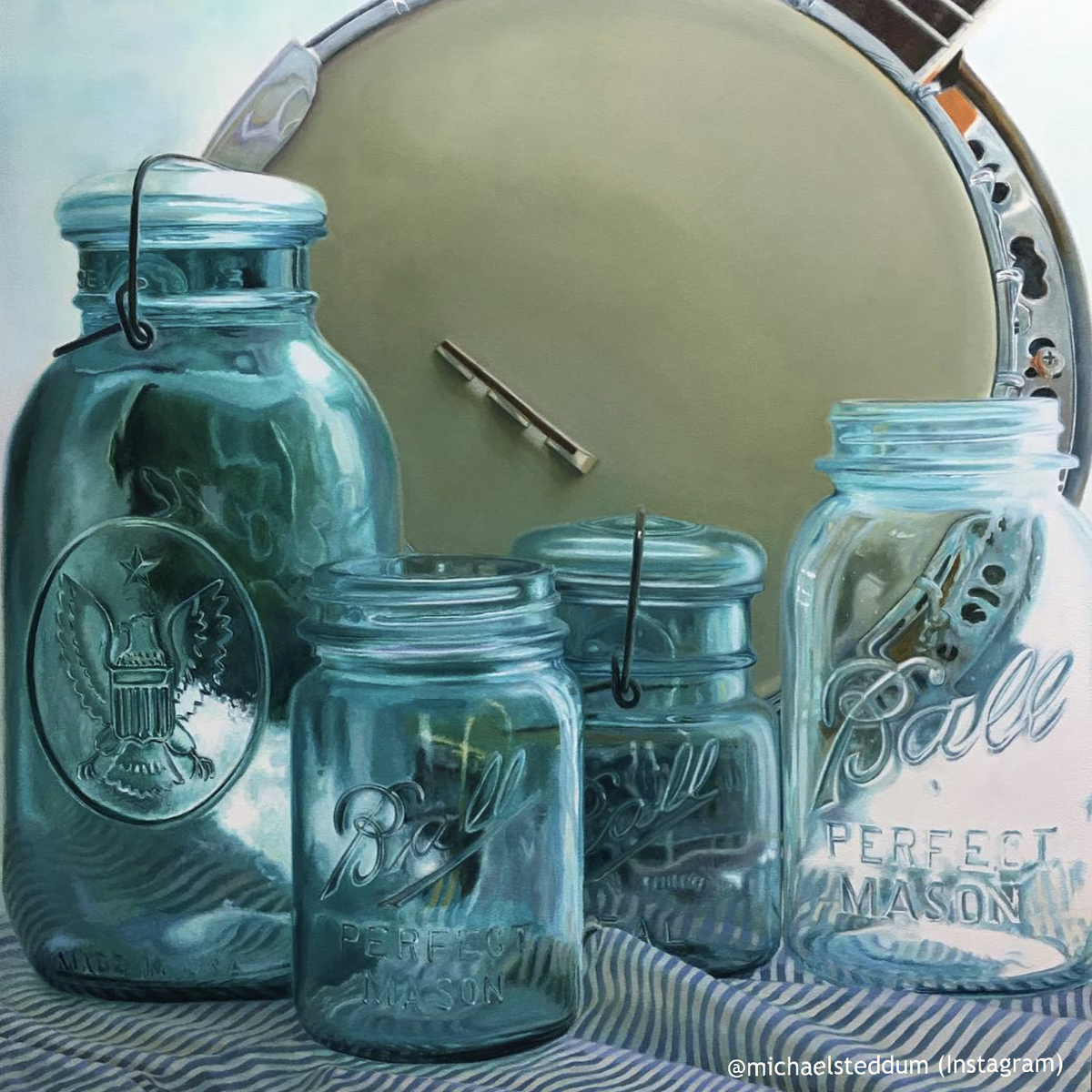 A variety of Vintage blue Ball regular mouth quart mason jar against a white background together with a cloth and a pan
