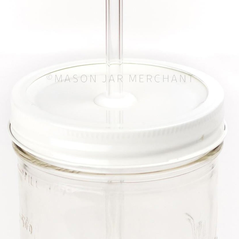 a close up of a white custom painted straw lid on a 24 oz glass mason jar with a glass reusable straw