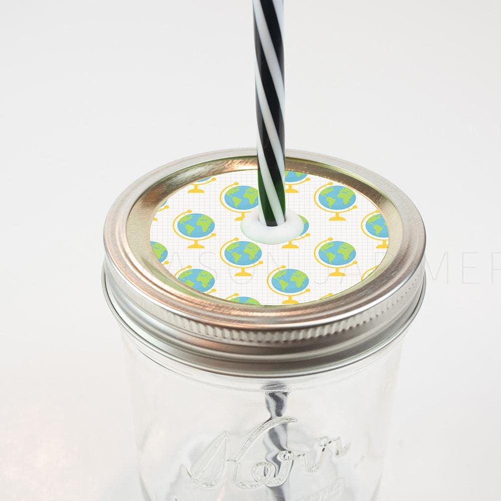 Silver lid with a globes on graph paper patterned mason jar straw lid against a white background.