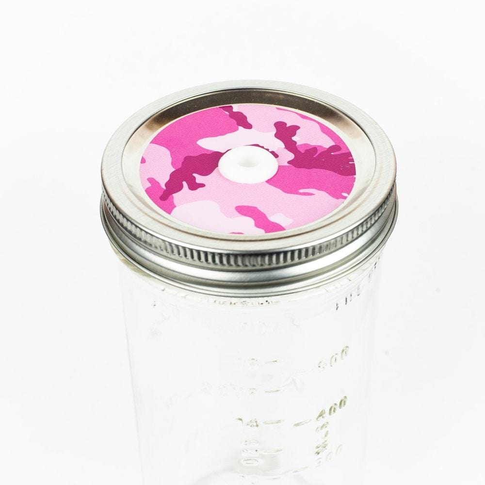 Silver lid with a pink camouflage patterned mason jar straw lid against a white background.