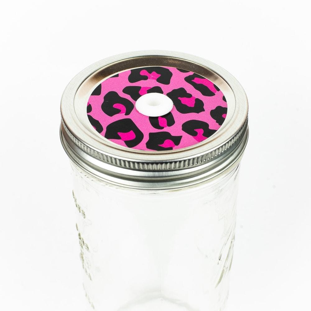 Silver lid with a pink leopard patterned mason jar straw lid against a white background.