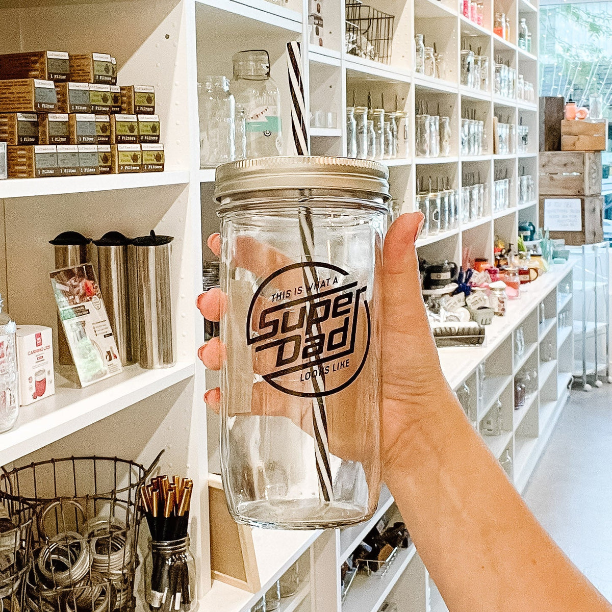 hand holding a mason jar tumbler that says "this is what a SUPER DAD looks like"