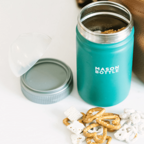 Photo of stainless steel mason bottle with straw top in forest green being reused as a snack cup. Photographed against white countertop.