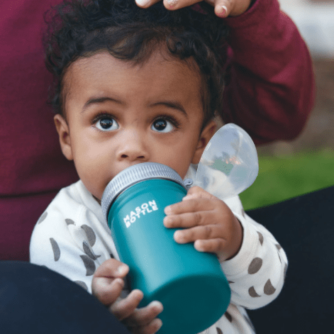 Photo of a child drinking from a stainless steel mason bottle with straw top in forest green.