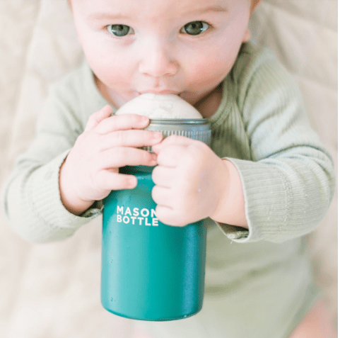 Photo of a child drinking from a stainless steel mason bottle with straw top in forest green.