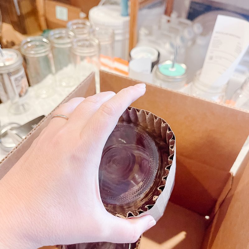 A jar being wrapped in corrugated cardboard
