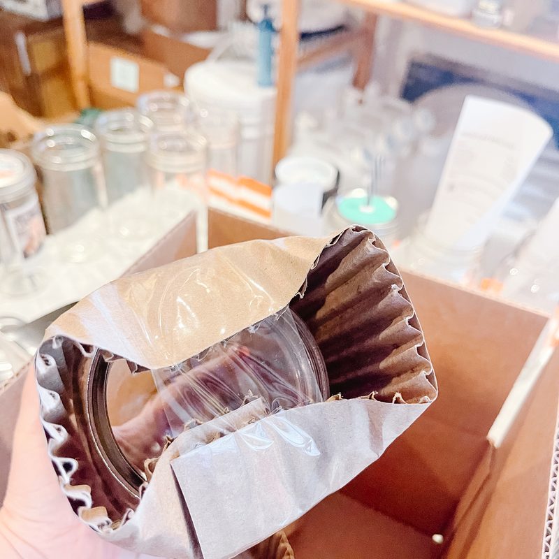 The cardboard folded over the mouth of the jar